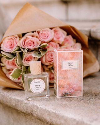 Chai nước hoa thuần chay Poécile Rose Lutèce Paris nắp gỗ và vỏ hộp đặt cạnh bó hoa hồng phấn dành cho cung hệ Khí.