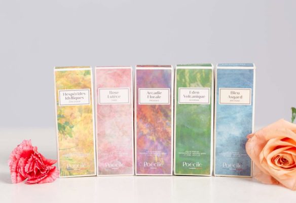 Bộ 5 hộp nước hoa mini Poécile họa tiết màu nước nghệ thuật gồm Hespérides Idylliques, Rose Lutèce, Arcadie Florale, Eden Volcanique và Bleu Asgard đặt cạnh hoa hồng.